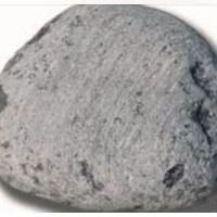 Una gran roca gris reposa sobre una superficie blanca.