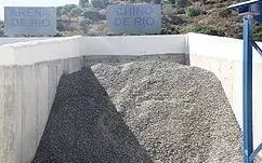Un montón de grava está junto a un muro de hormigón.