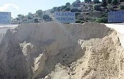 Un montón de arena se encuentra al costado de una carretera.