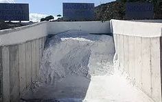 Una gran pila de nieve se encuentra encima de un muro de hormigón.
