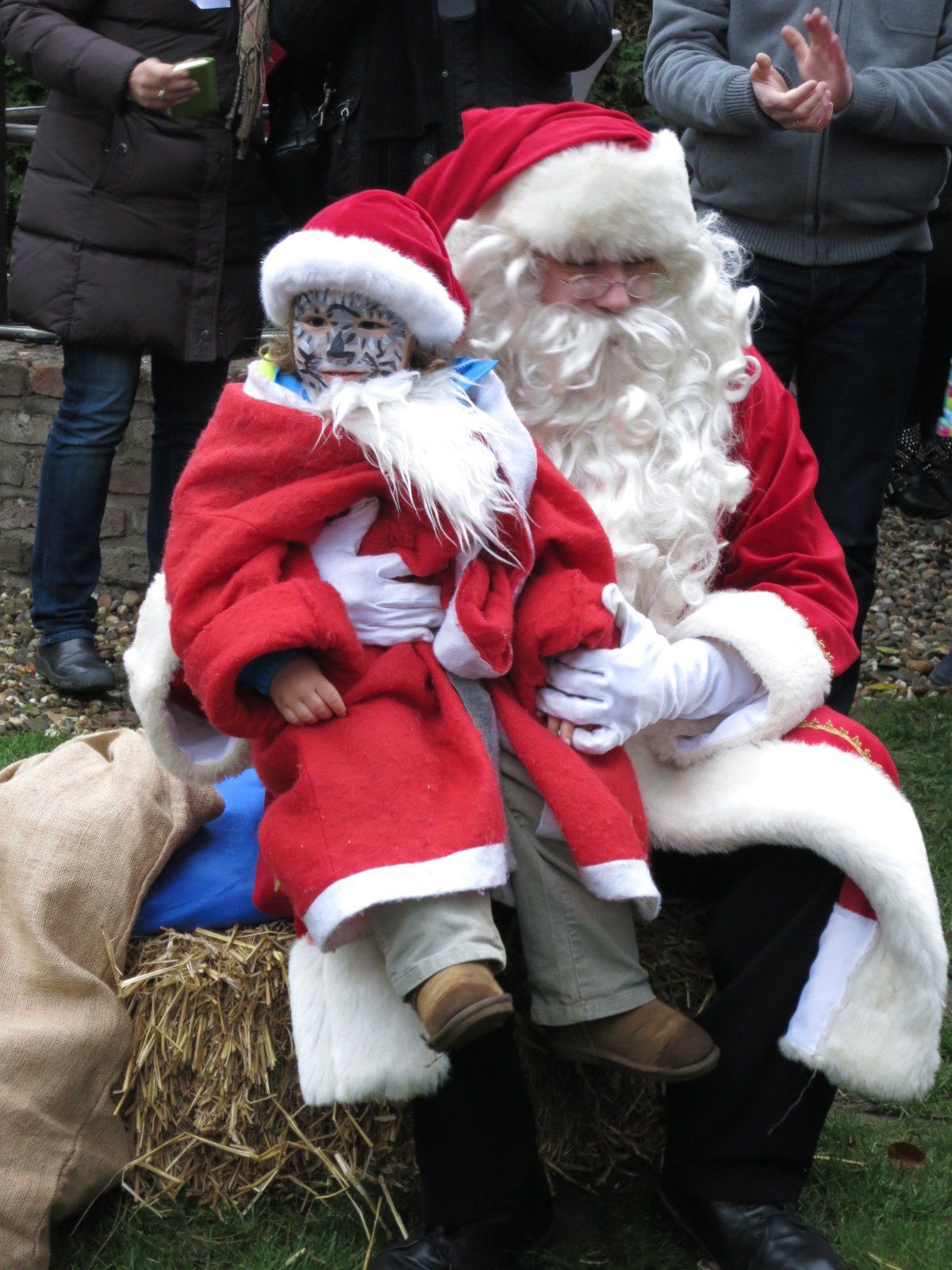 Kind sitzt auf dem Schoß vom Weihnachtsmann