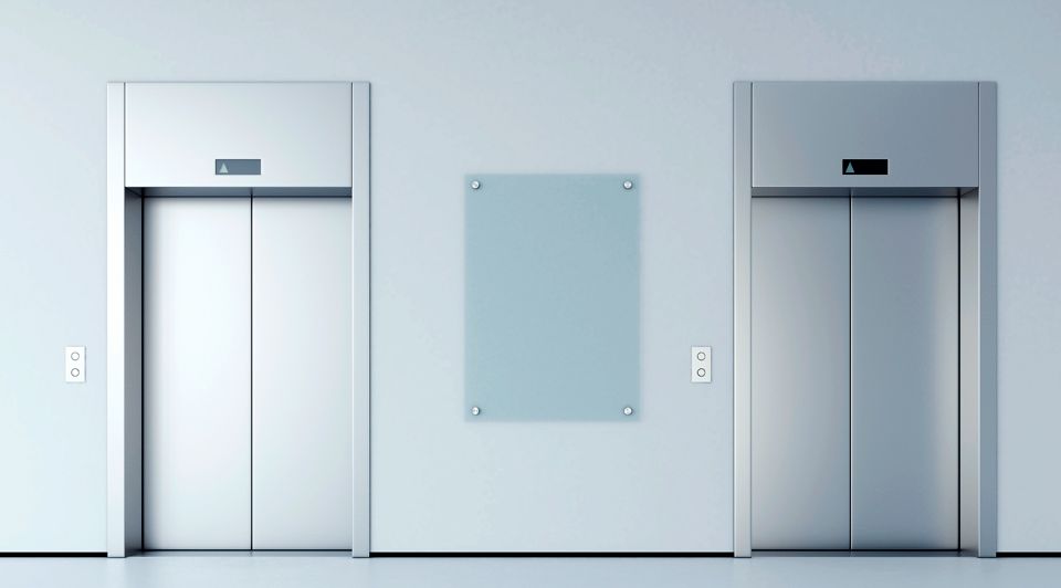 Tres ascensores están alineados uno al lado del otro en un pasillo.