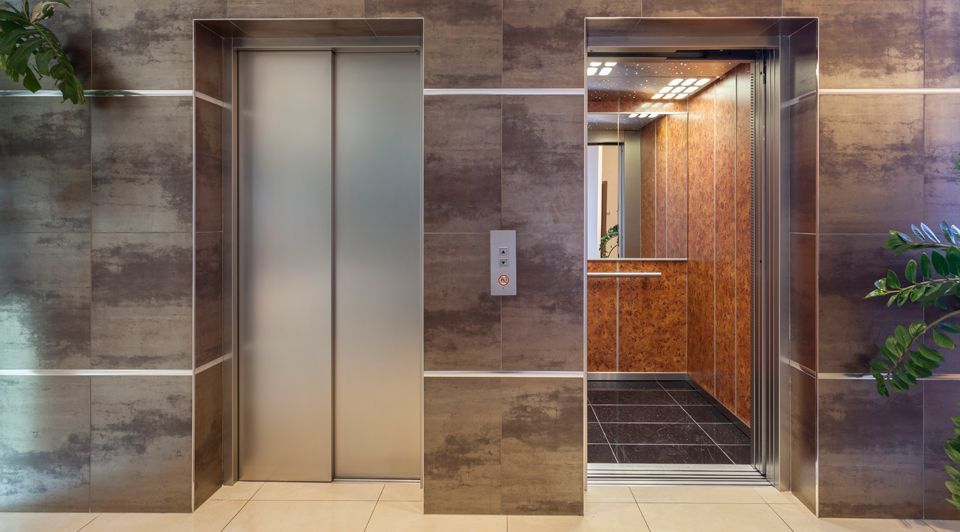 Hay dos ascensores uno al lado del otro en un edificio.