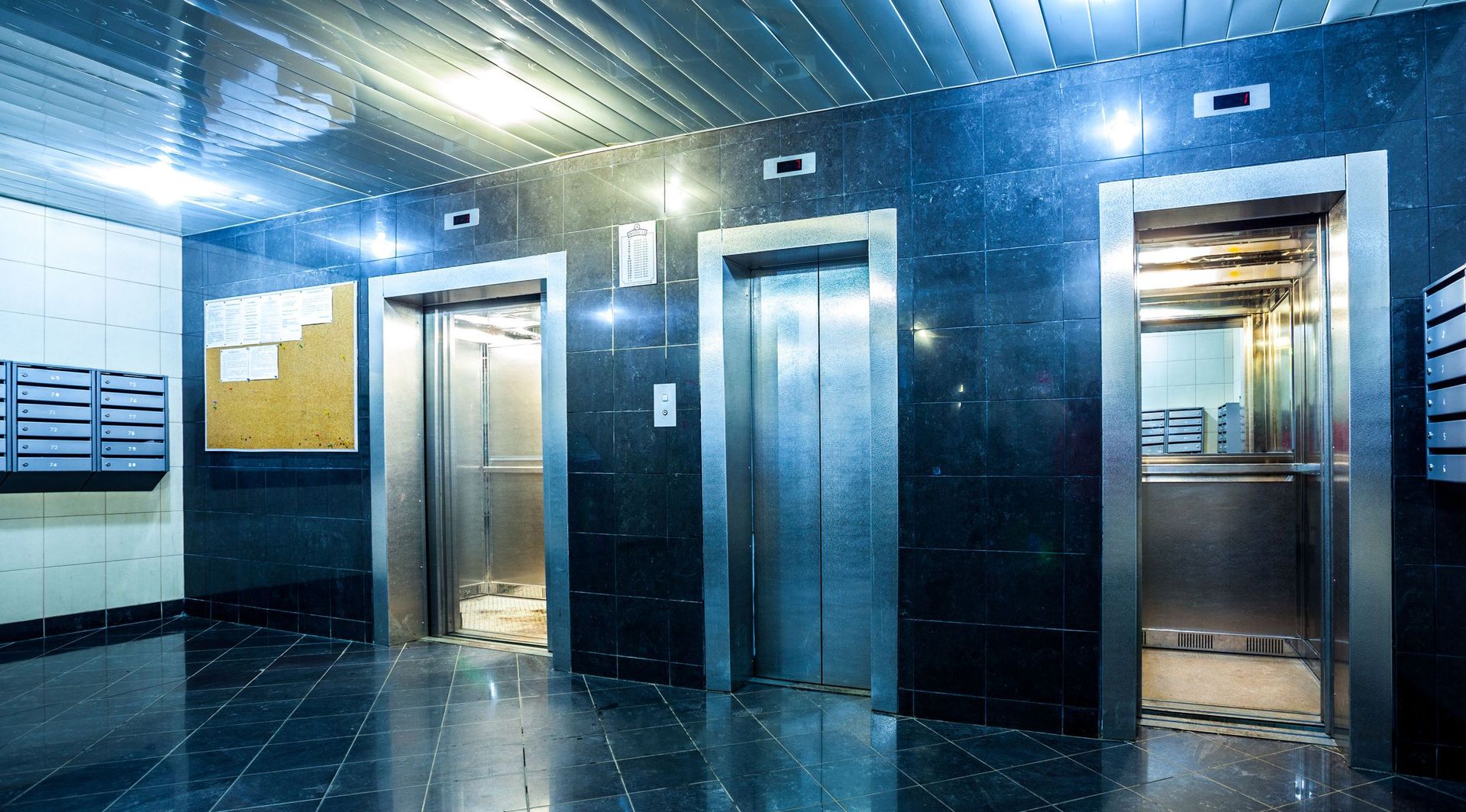 Hay tres ascensores en el vestíbulo de un edificio.