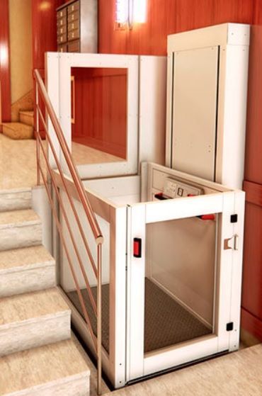 Un ascensor blanco está parado en medio de una escalera.