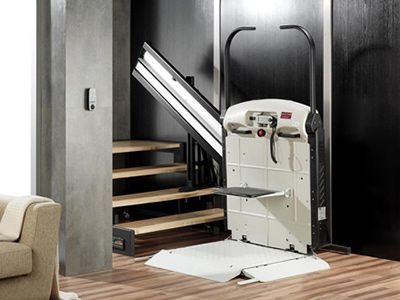 Hay un salvaescaleras en una sala de estar al lado de un sofá.