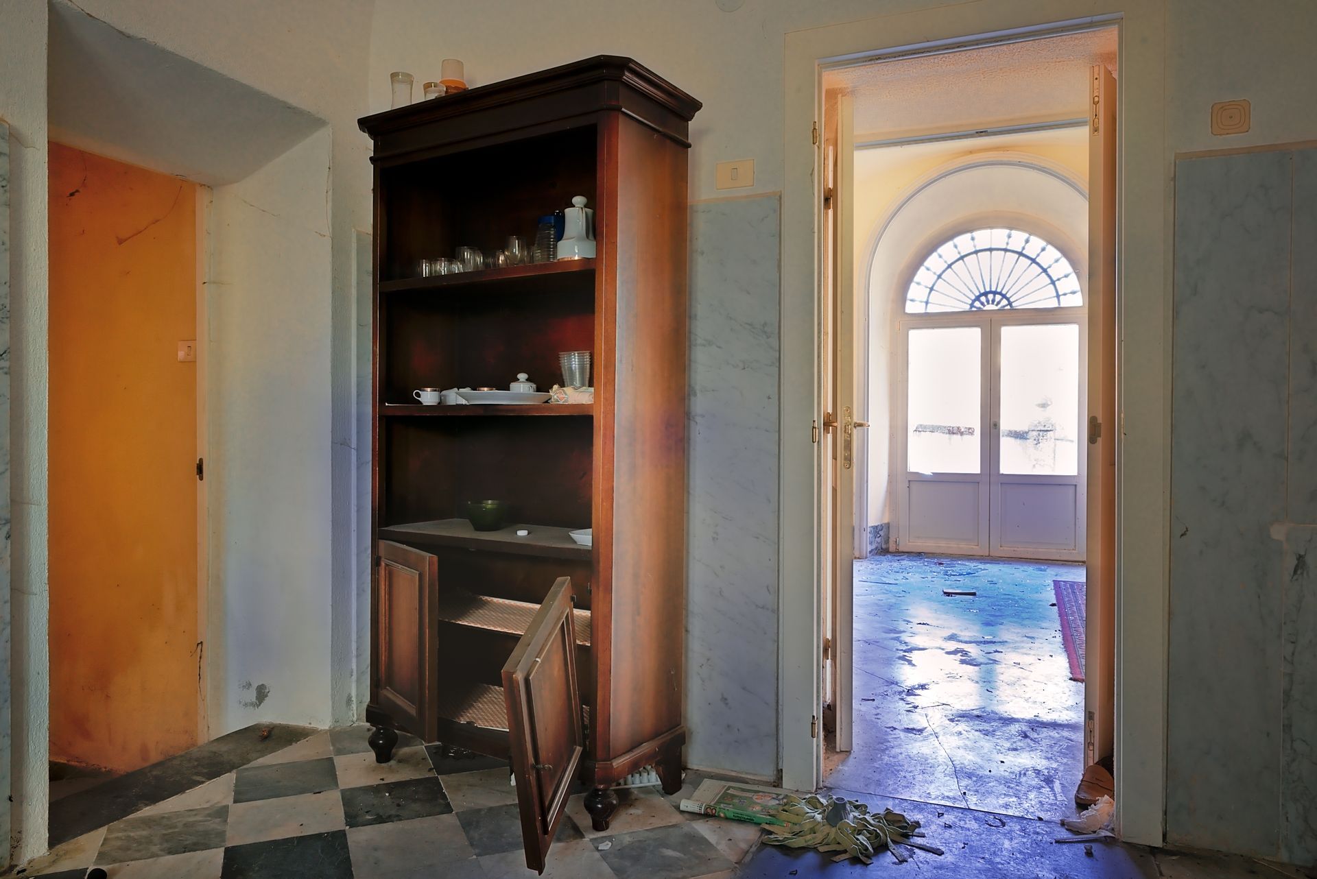 Couloir abandonné avec une armoire en bois.