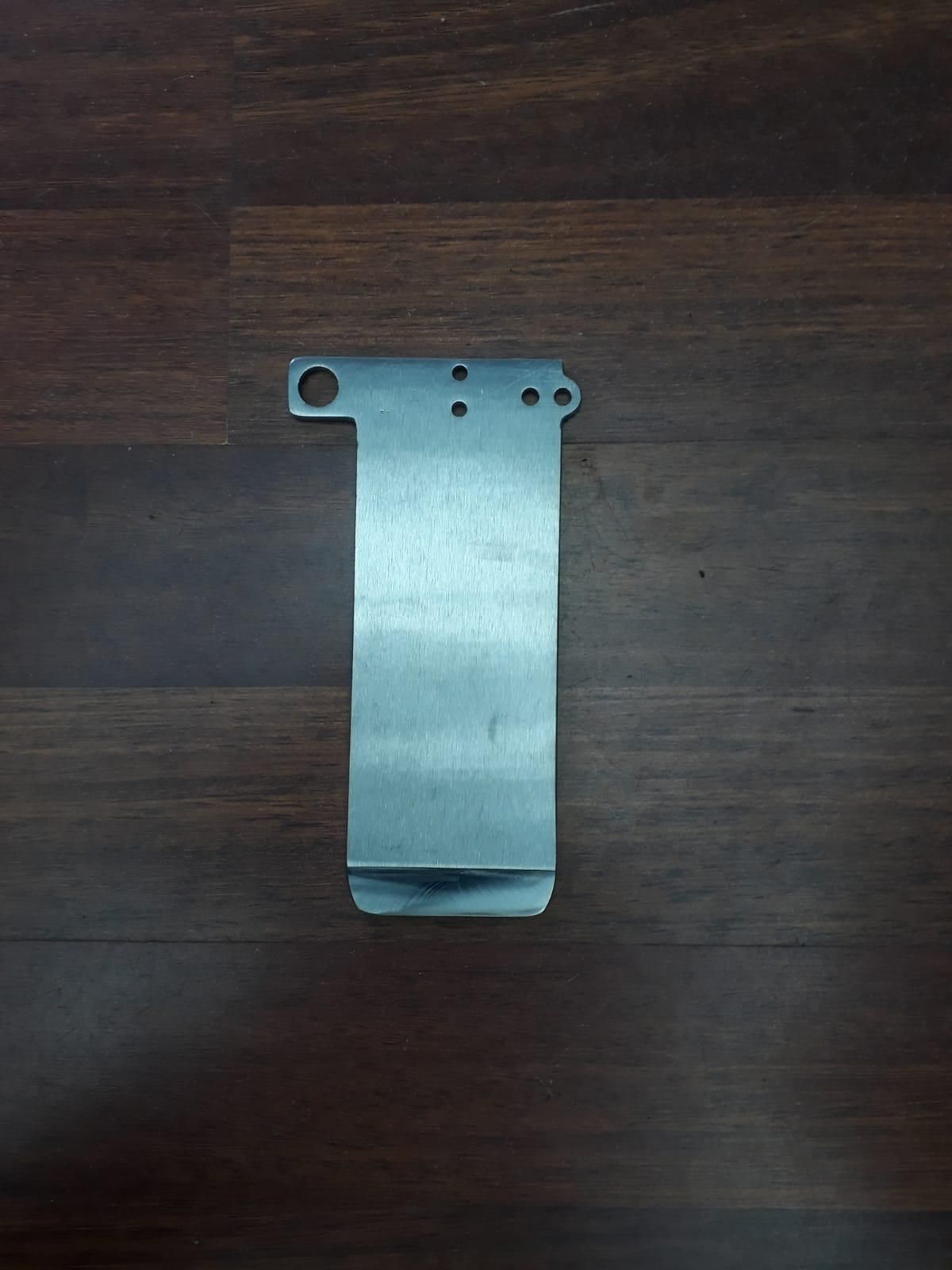 Un trozo de metal está sobre una mesa de madera.