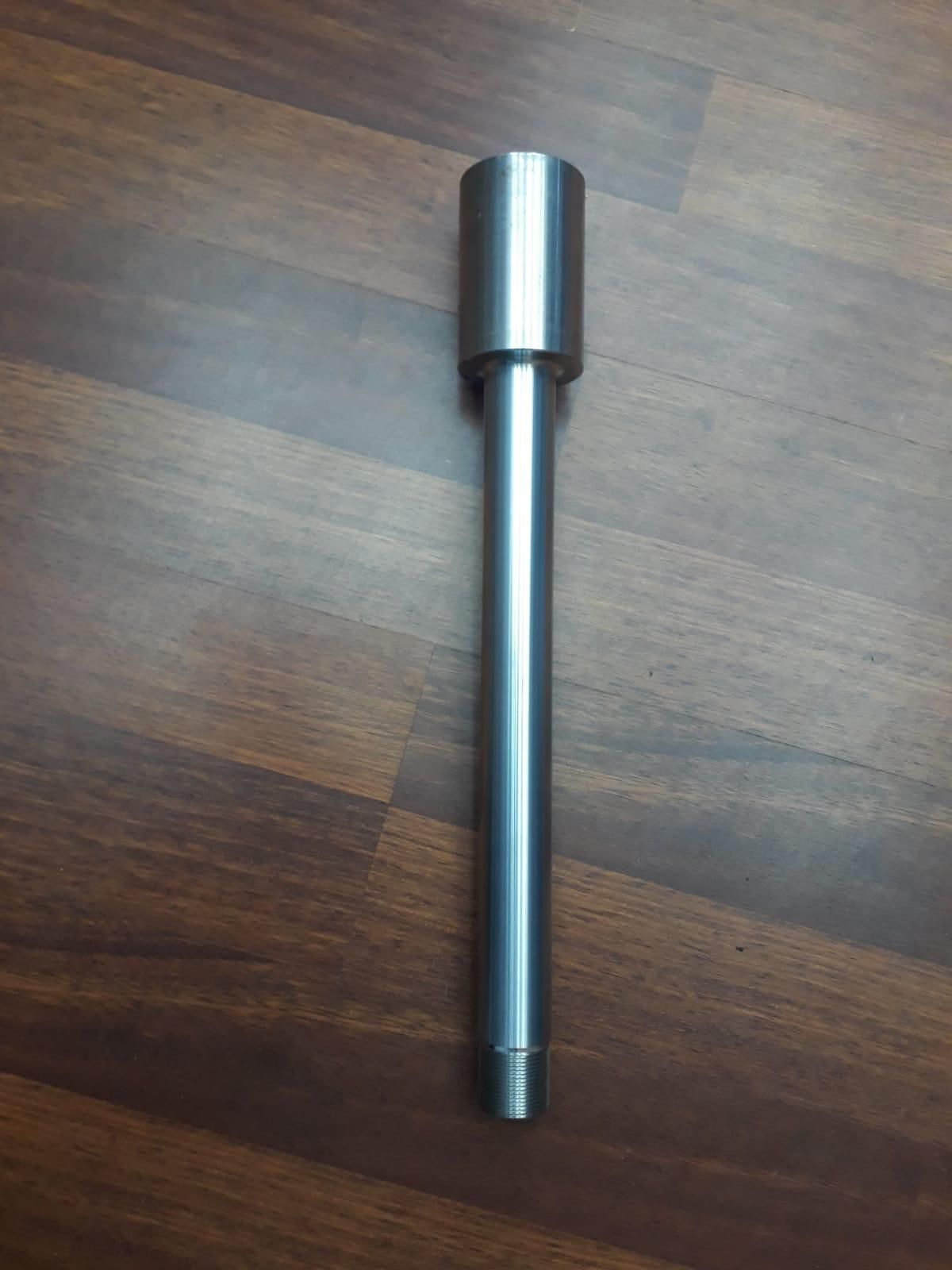 Un tubo de metal está sobre un piso de madera.