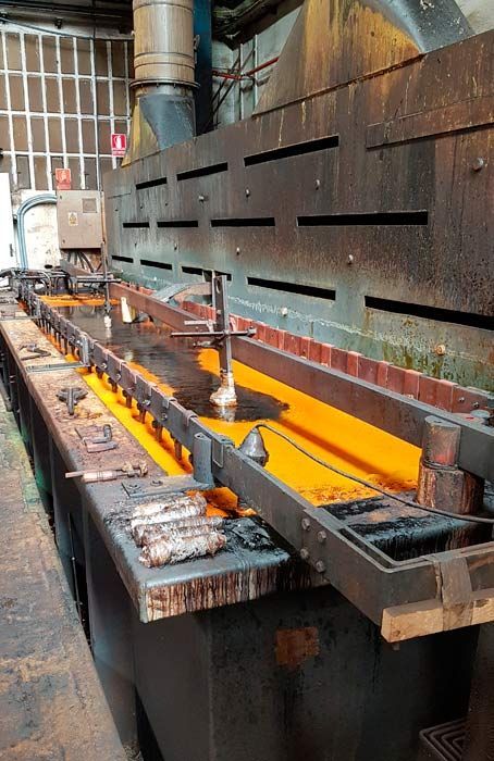 Una fila de tanques de metal llenos de líquido naranja en una fábrica.