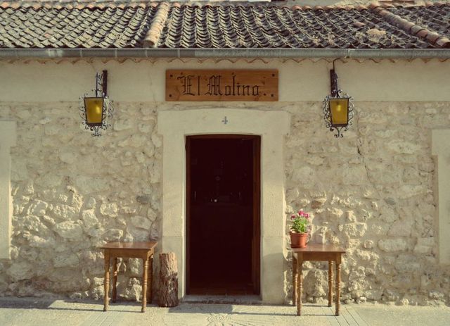 Un edificio de piedra con un cartel que dice el molino.