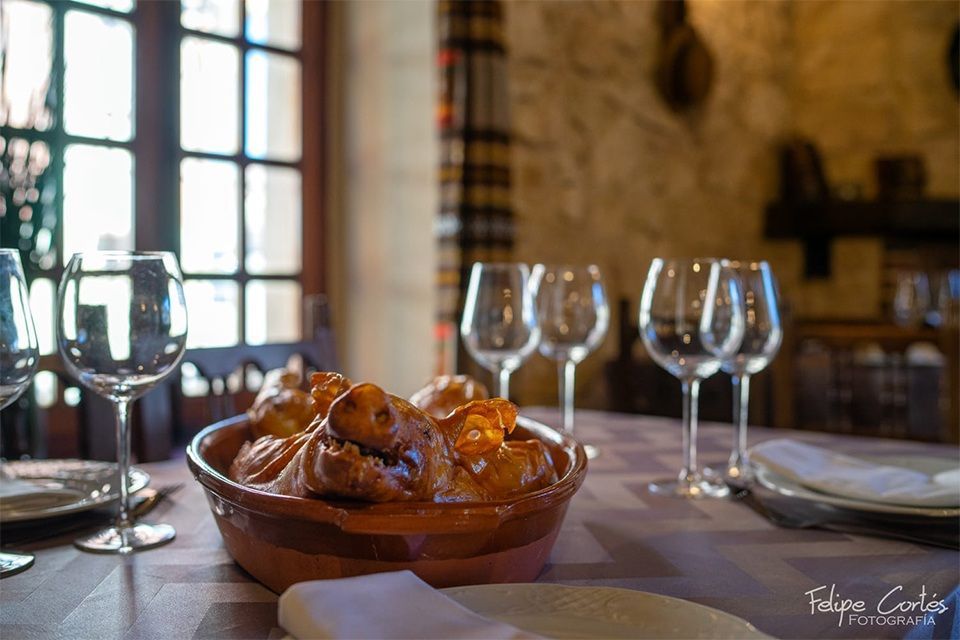 Un plato de comida está sobre una mesa al lado de copas de vino.