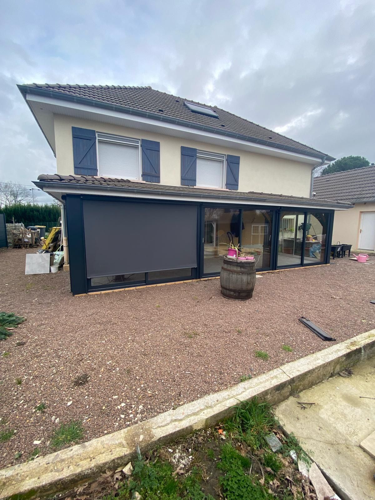 Véranda à stores roulants fermés sur une vitre