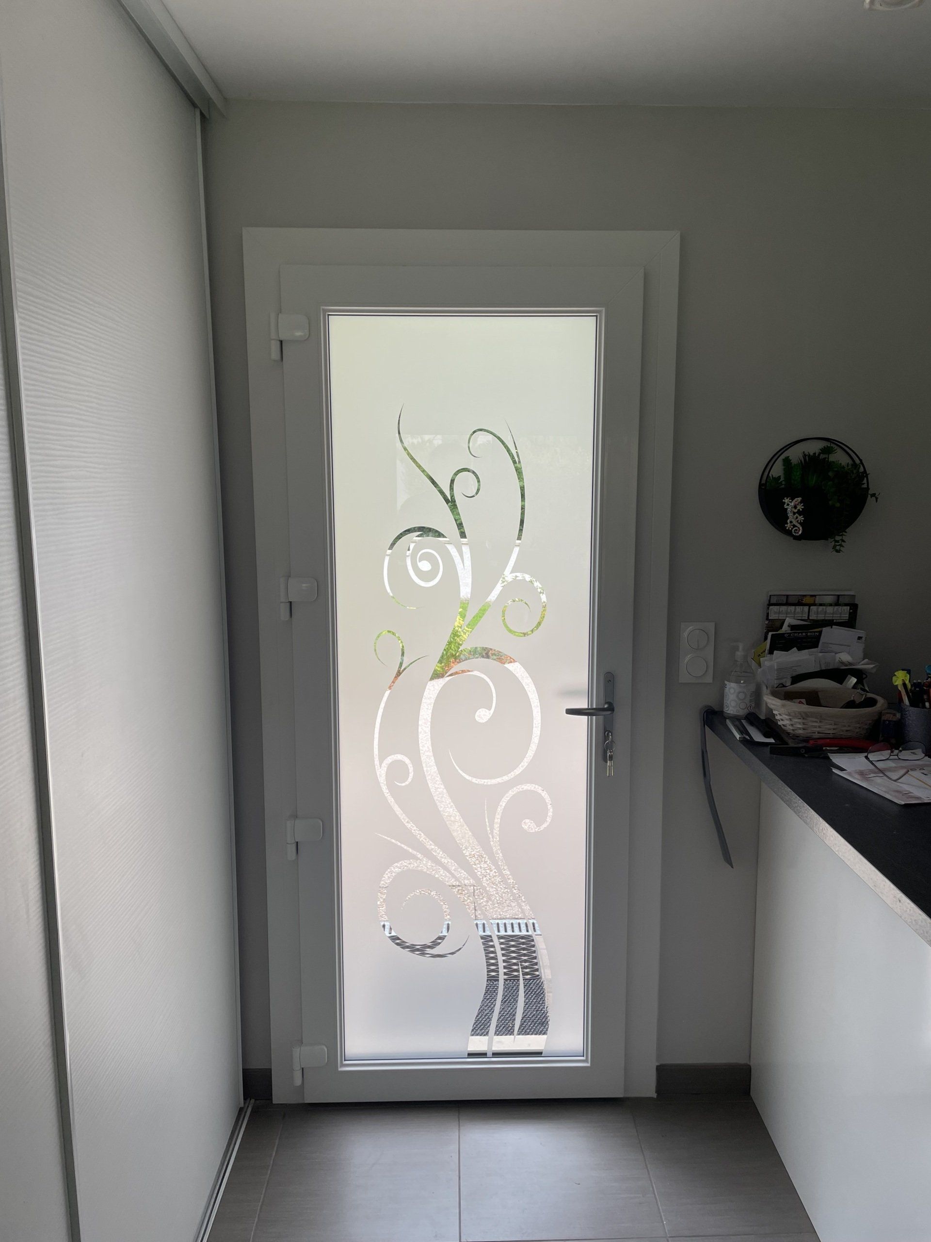 Vue intérieure sur une porte d'entrée vitrée avec dessin