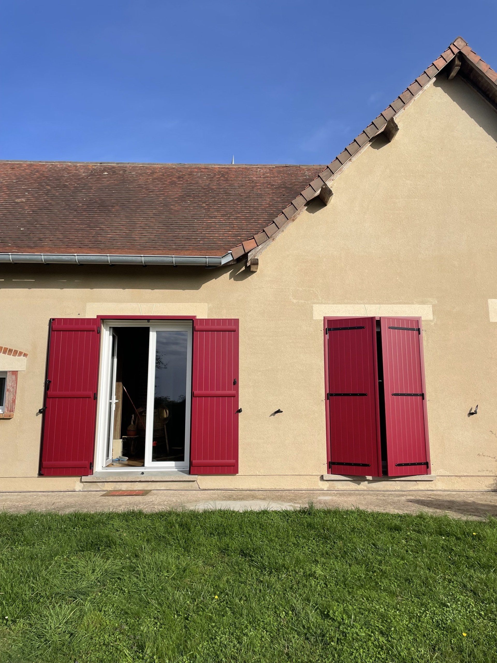 Portes-fenêtres avec des volets rouges ouverts et fermés