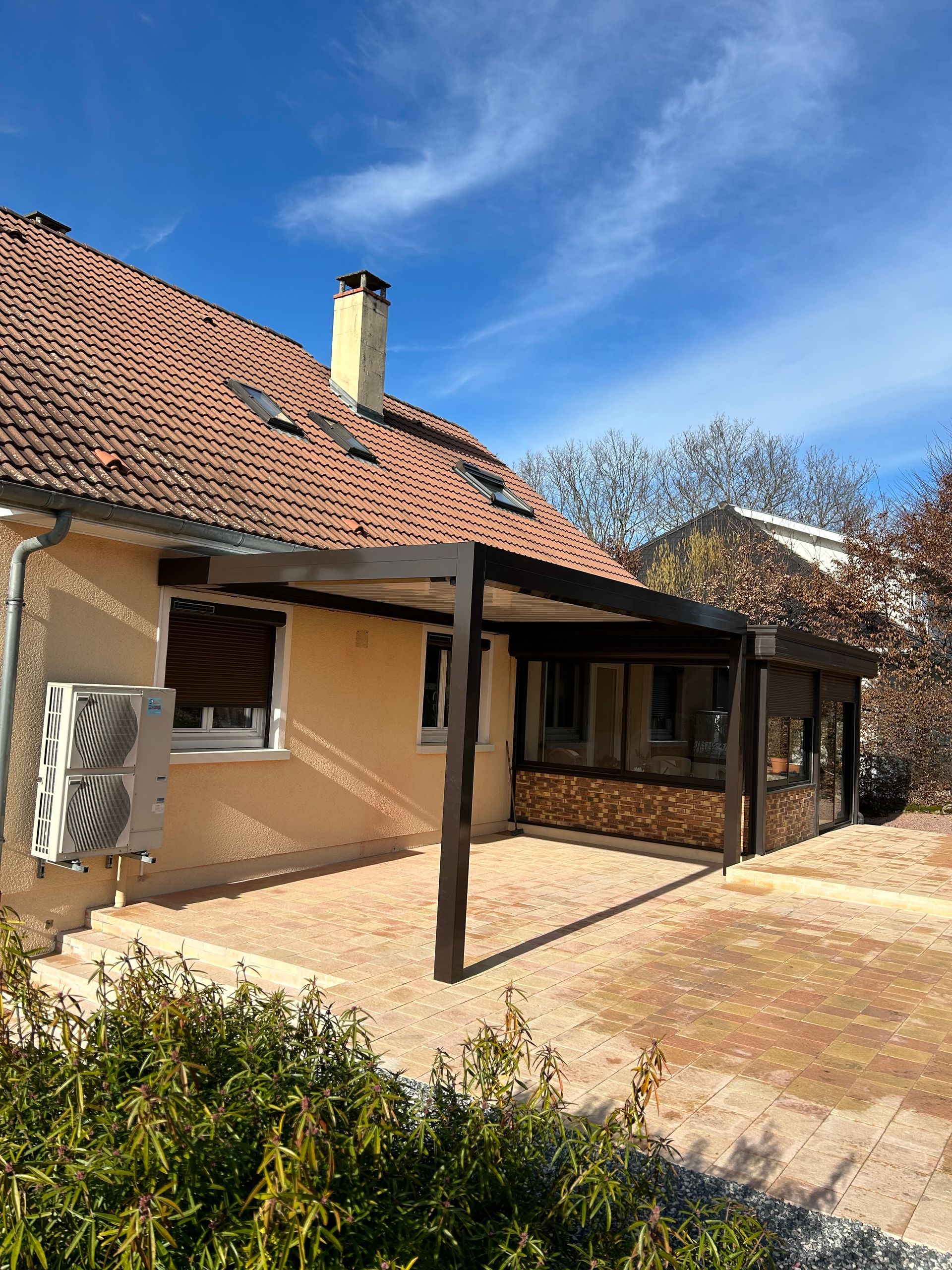 Pergola en PVC et aluminium accrochée à une maison
