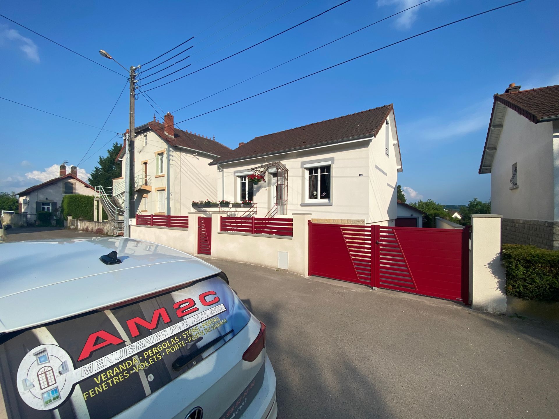 Clôture devant une maison avec un portail rouge