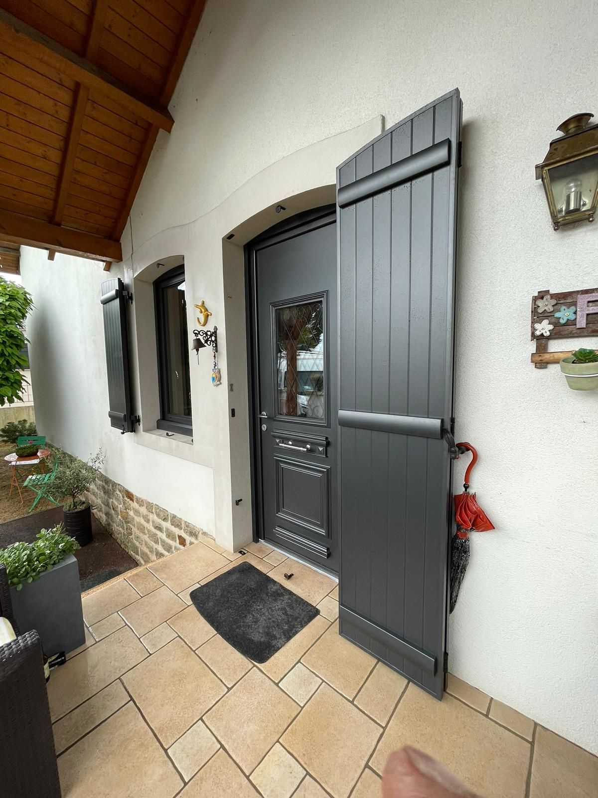 Porte vitrée et fenêtre avec un volet battant ouvert