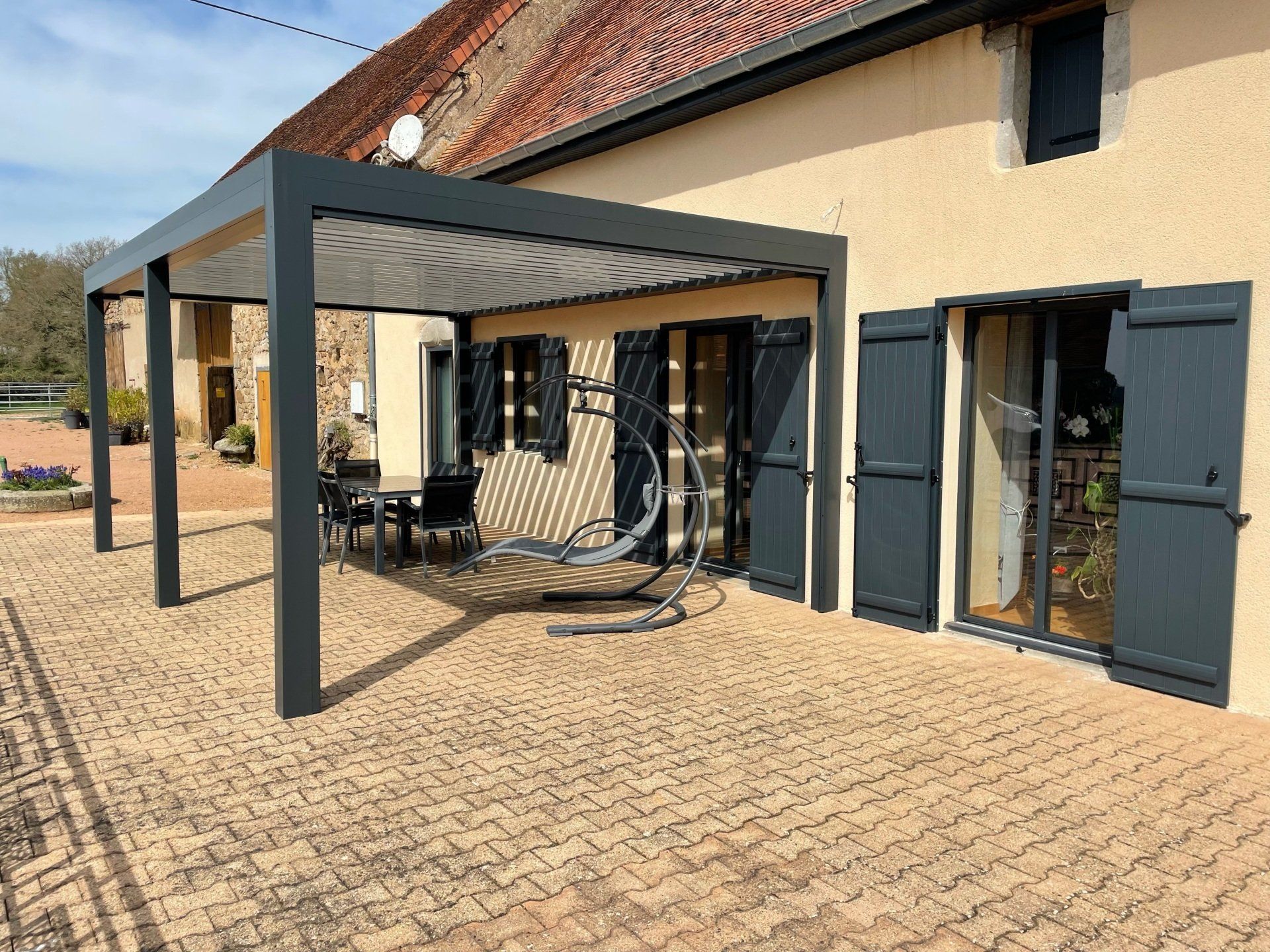 Pergola ouverte qui recouvre une terrasse de maison