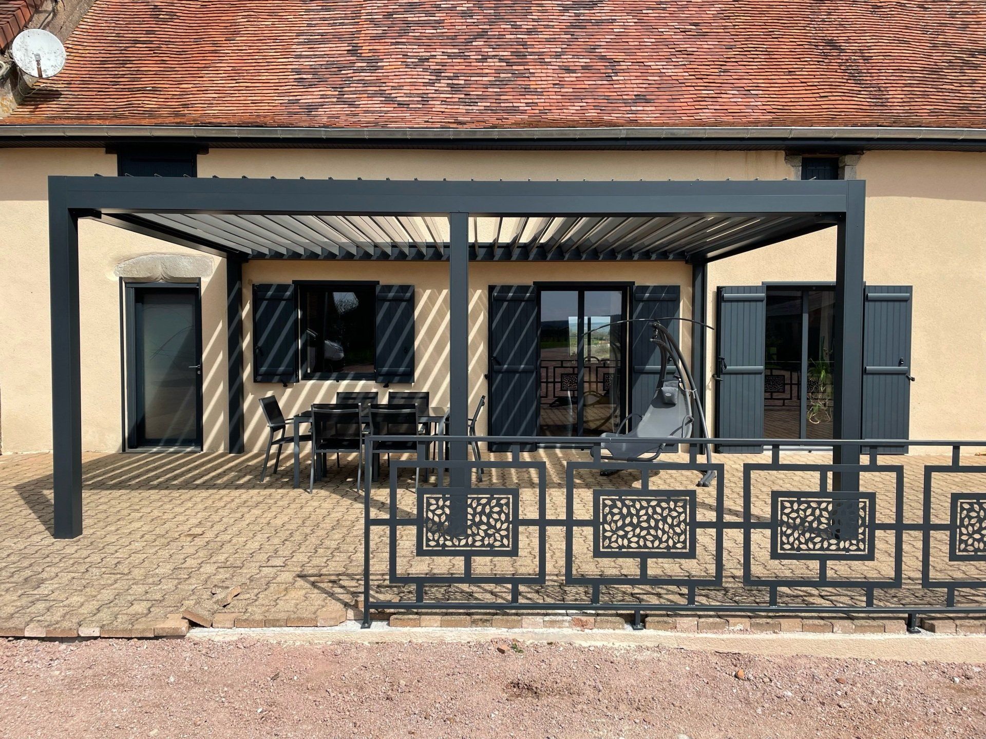 Vue sur la terrasse extérieure d'une maison avec pergola