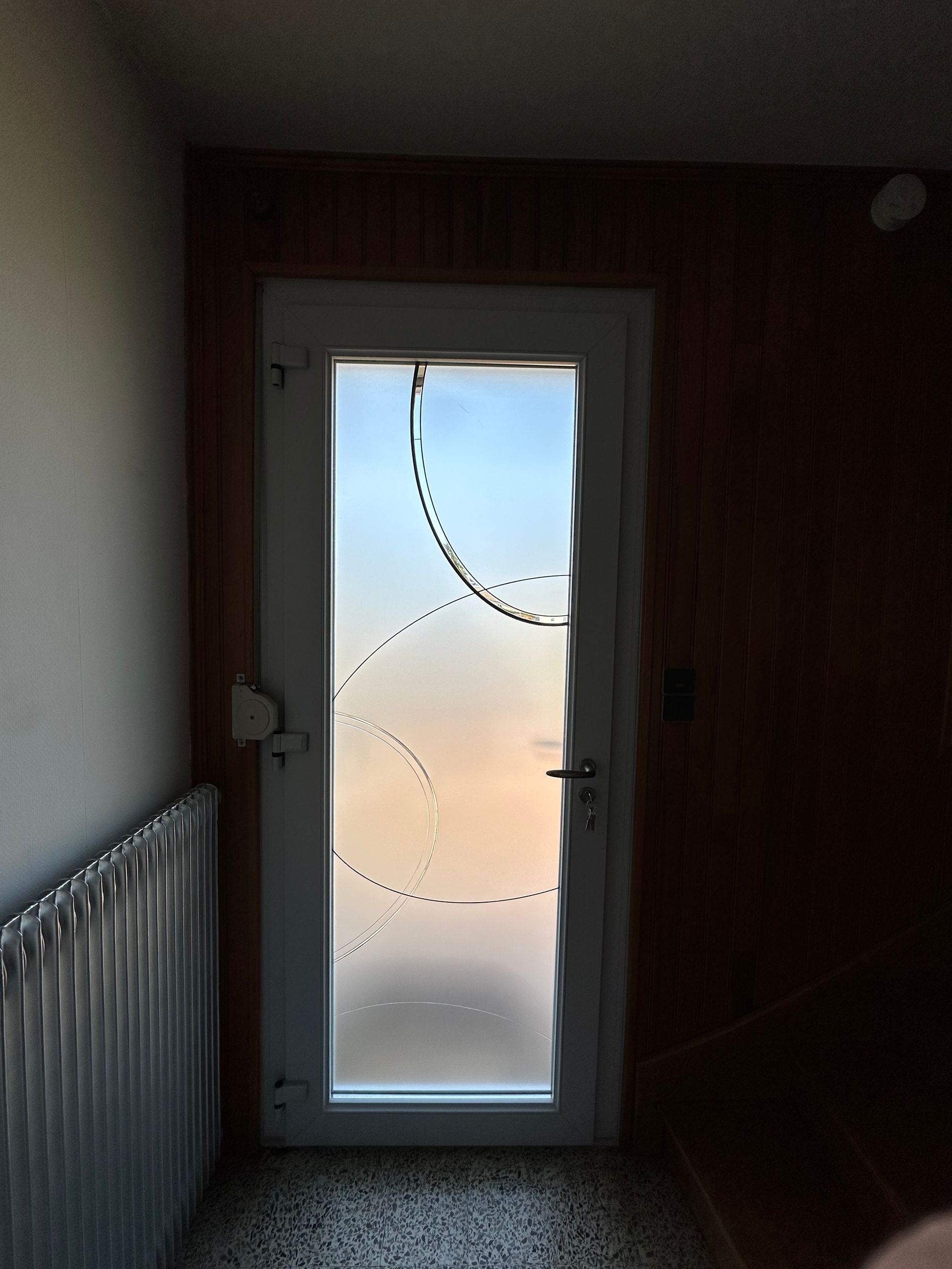 Porte d'entrée vitrée prise de l'intérieur