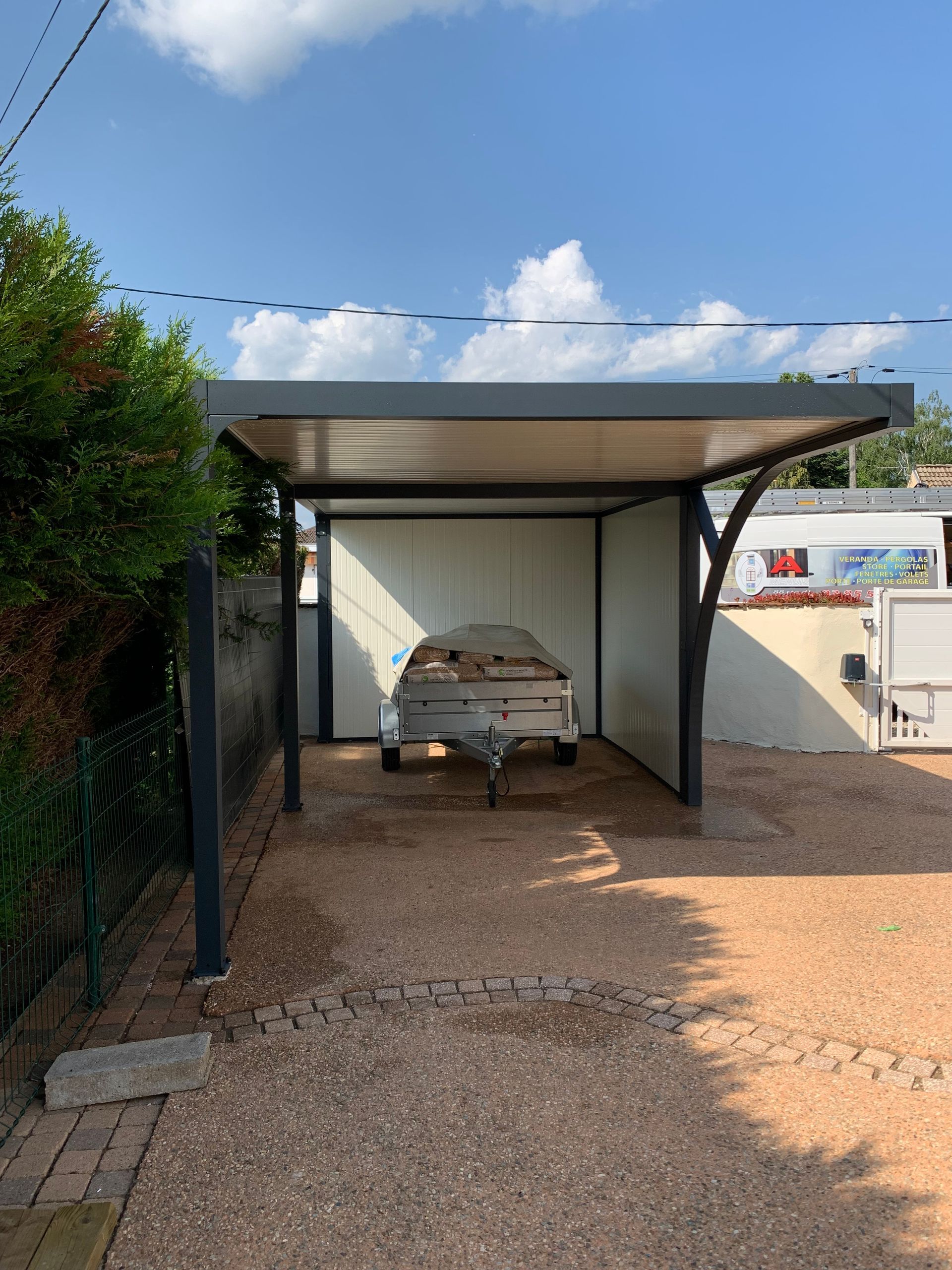 Carport qui abrite une remorque