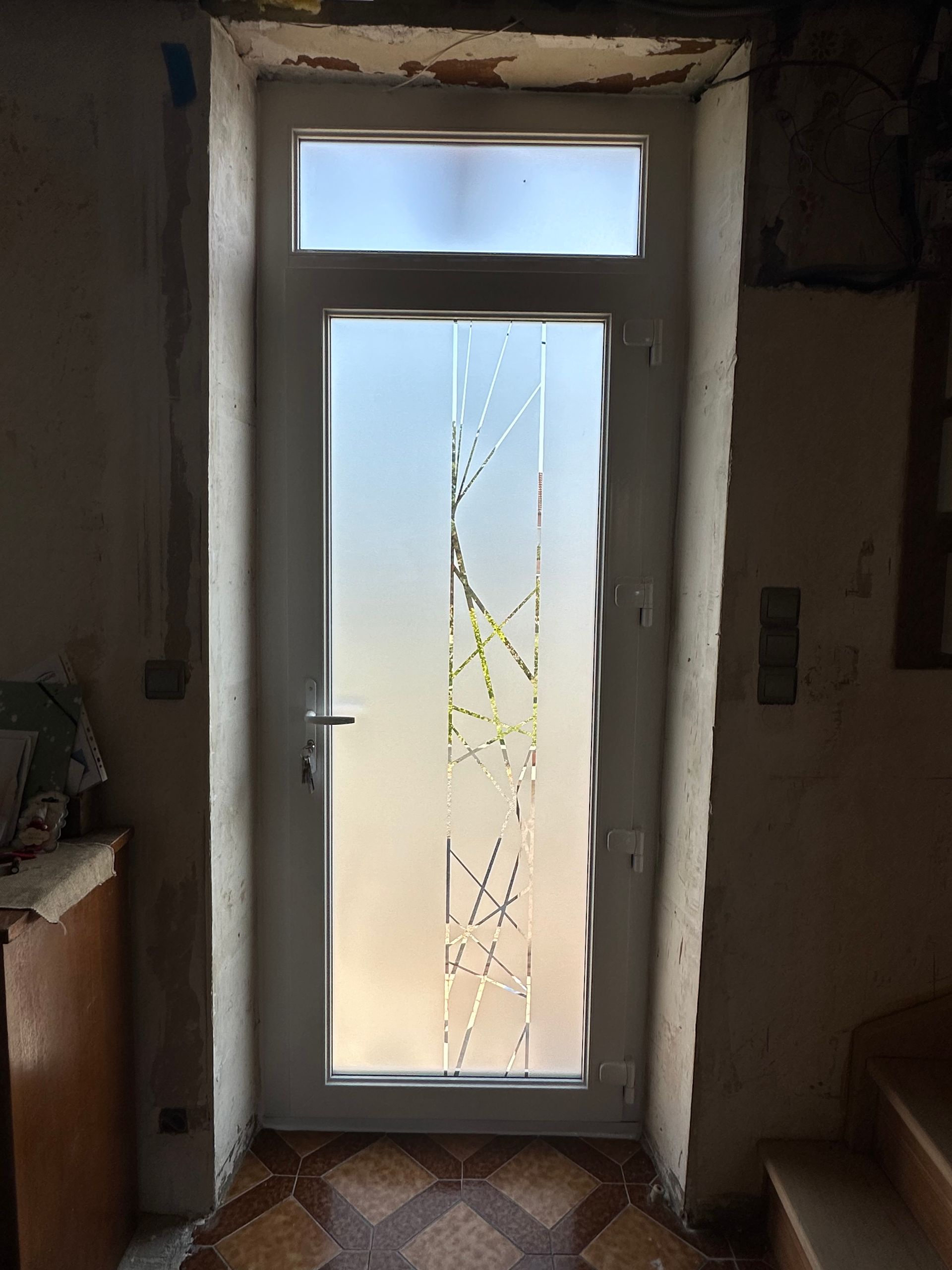 Porte d'entrée vitrée avec dessin, prise de l'intérieur