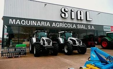 Fachada de un concesionario de maquinaria agrícola con tractores estacionados afuera y letrero con la palabra "SIAL".
