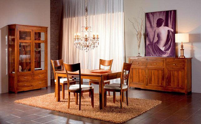 Comedor con muebles de madera: mesa, sillas, aparador y bufet, con alfombra y obras de arte.