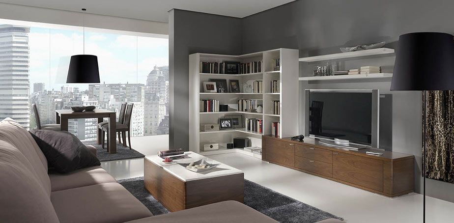 Salón moderno con colores neutros, un gran ventanal y estanterías y armarios empotrados.