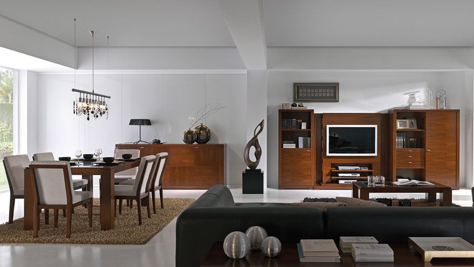 Salón moderno con zona de comedor, equipado con muebles de madera, sofá oscuro y televisor en la pared.