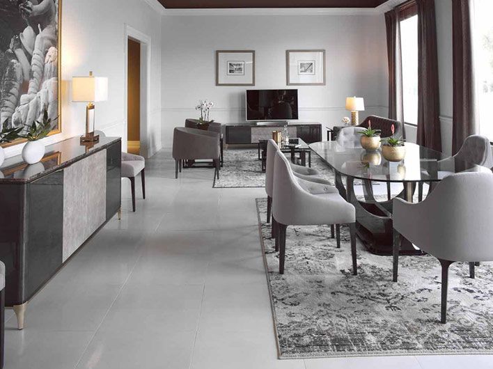 Elegante comedor con una mesa larga, sillas y aparador. Colores neutros.