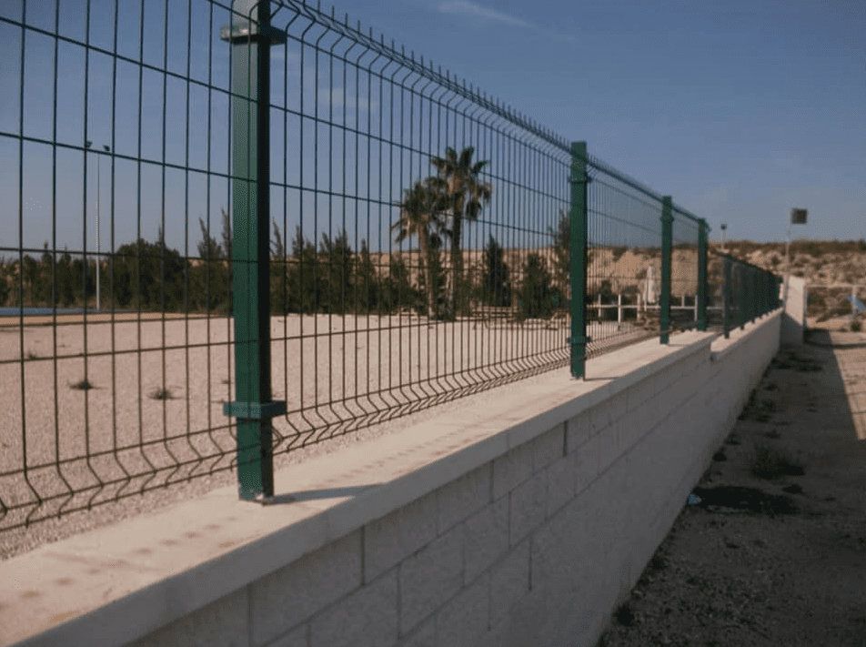 Un muro de piedra con un poste de metal delante.