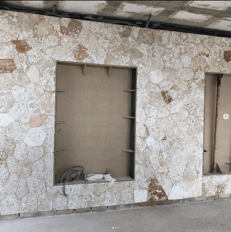 Un muro de piedra con una ventana en el medio.