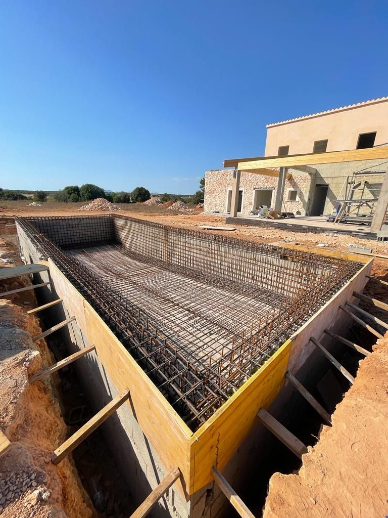 Se está construyendo una gran piscina en un campo de tierra.