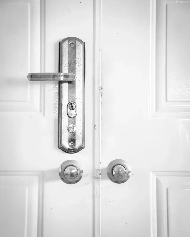 Un primer plano de una manija de puerta en una puerta blanca.