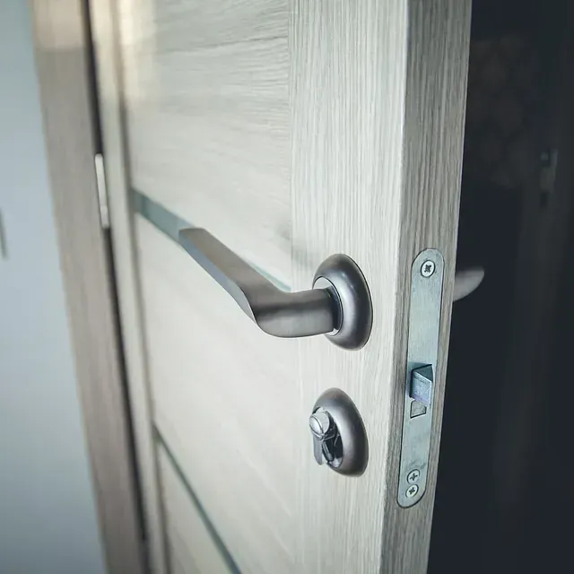 Un primer plano de una manija de puerta en una puerta de madera.