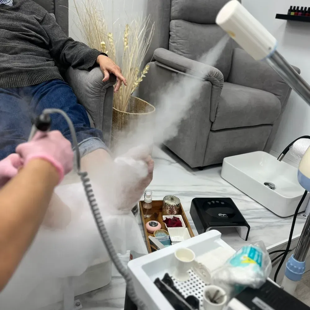 Persona que recibe un tratamiento de pies en un salón; se le aplica vapor.