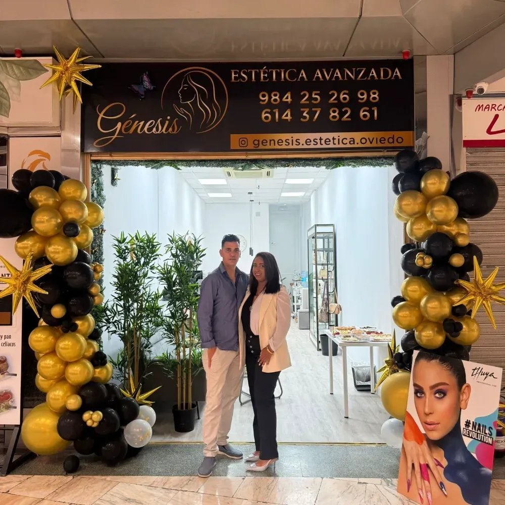 Pareja posa frente a la fachada de la tienda 