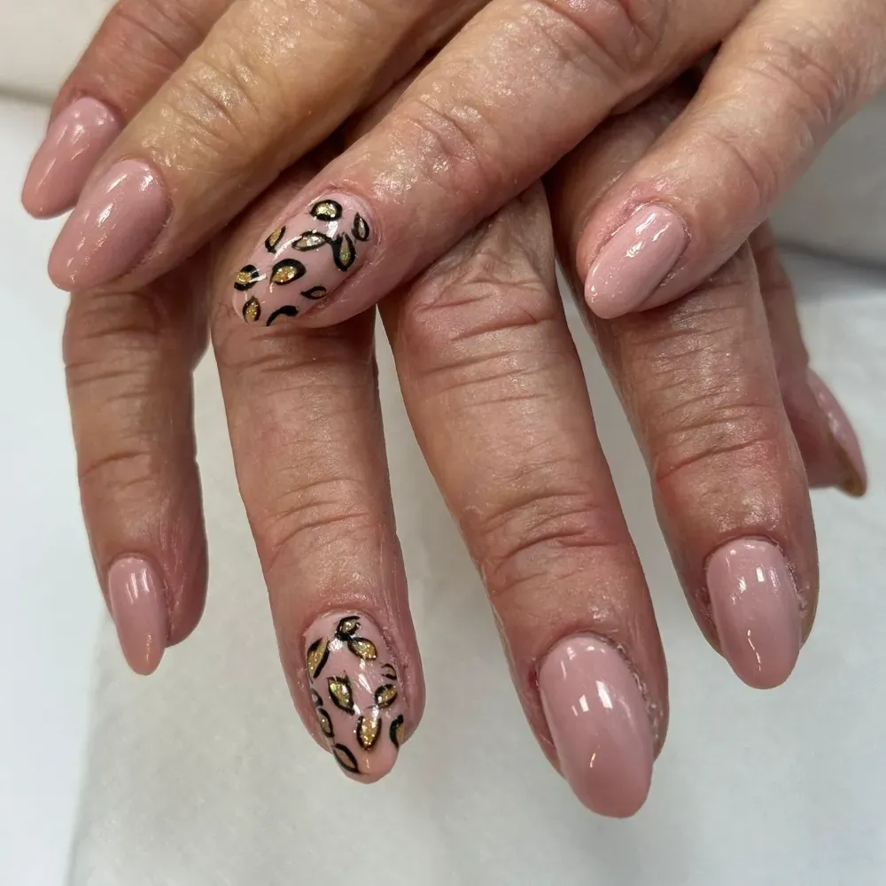 Manos con uñas en forma de almendra, en su mayoría de color rosa nude, con acentos de estampado de leopardo en los dedos anulares.