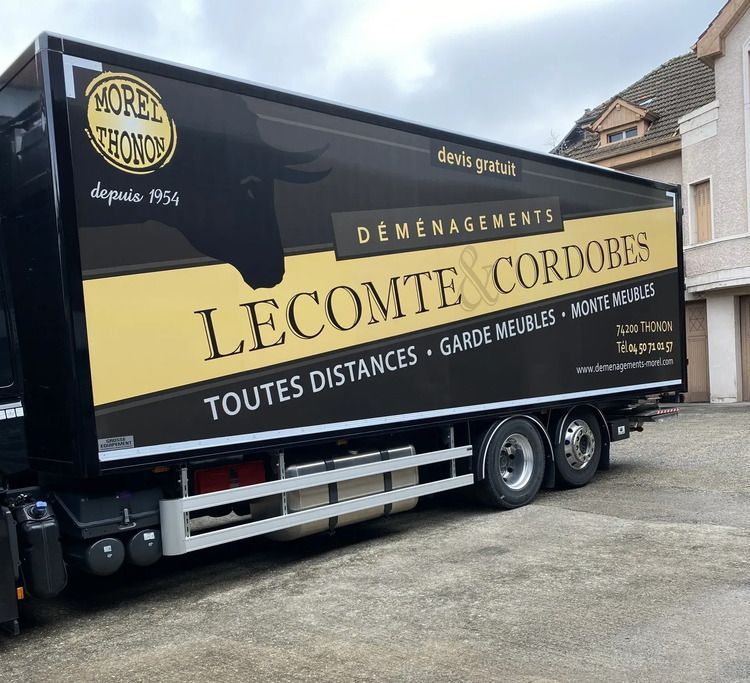 Un camion de déménagement noir avec un logo doré Transports Déménagements Lecomte