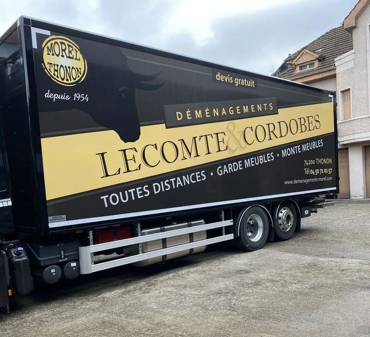 Un camion noir et doré avec le logo Transports Déménagements Lecomte