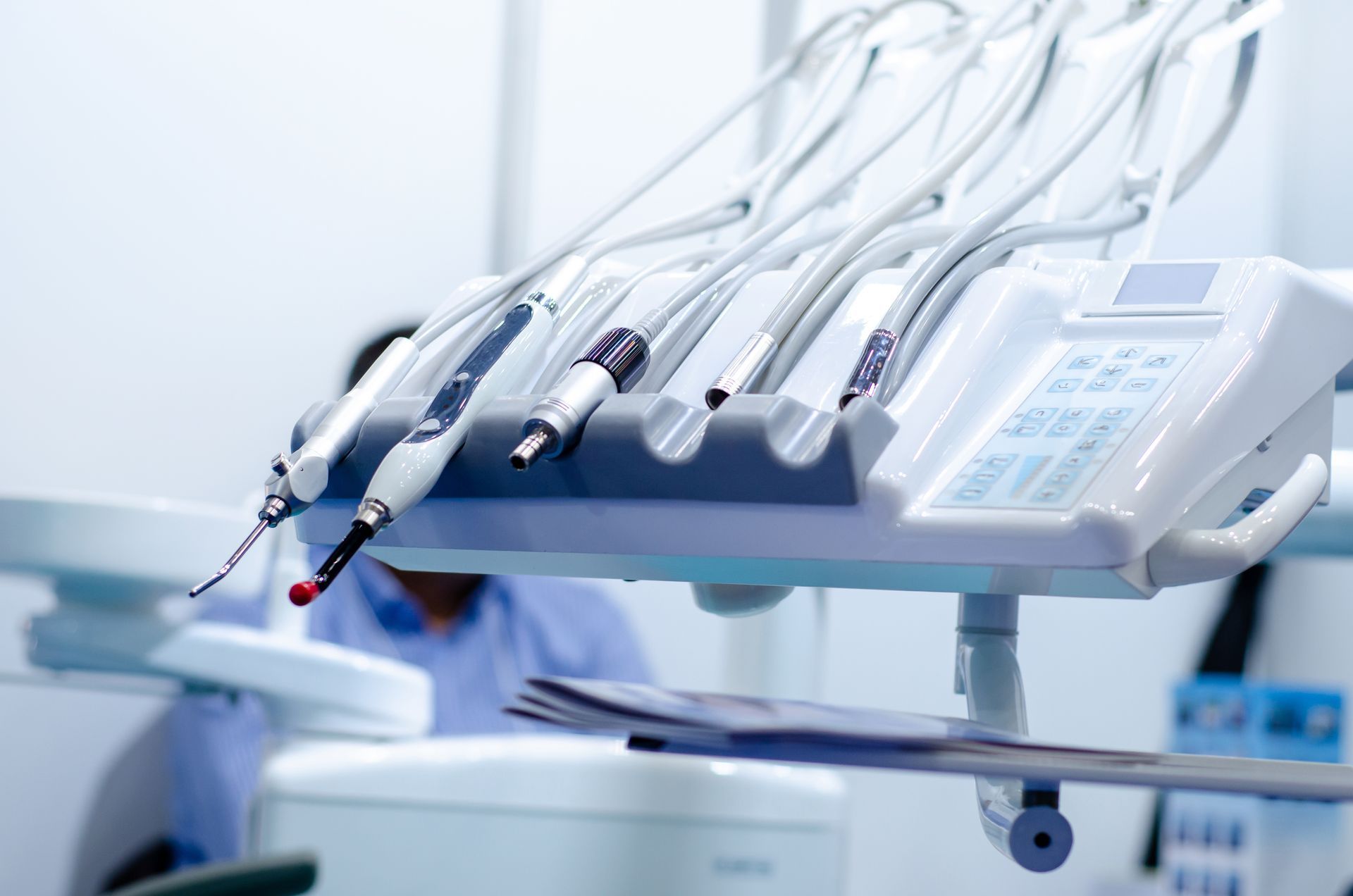Fauteuil de soins dentaires avec plusieurs pièces à main et tubes dans une salle de clinique lumineuse