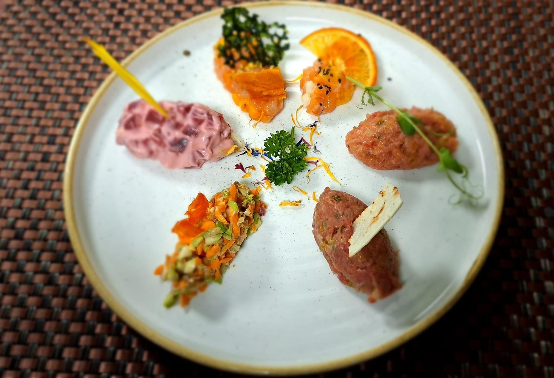 Un piatto bianco sormontato da una varietà di cibo su un tavolo.