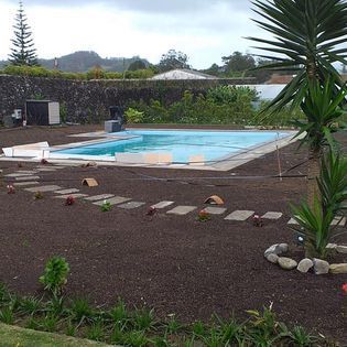 Piscina no meio de um jardim.