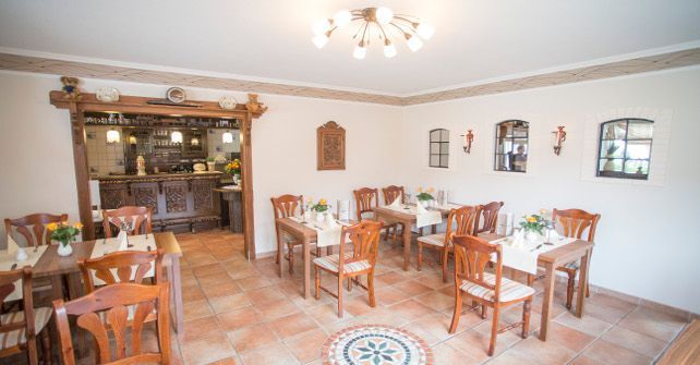Ein Esszimmer mit Tischen und Stühlen und einem Kronleuchter.
