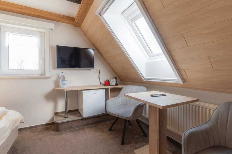 Ein Schlafzimmer mit zwei Betten, einem Stuhl und einem Tisch