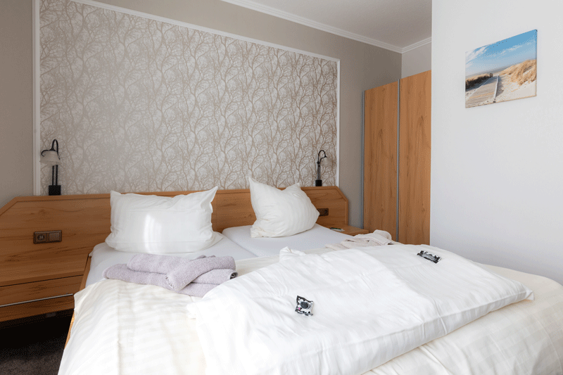In der Mitte des Zimmers steht ein großes Bett.