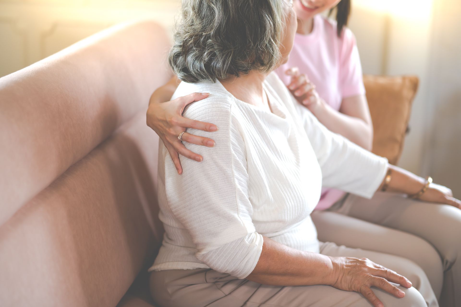 Un professionnel de la santé tient les mains d'une personne âgée, lui offrant soutien et réconfort à l'intérieur.