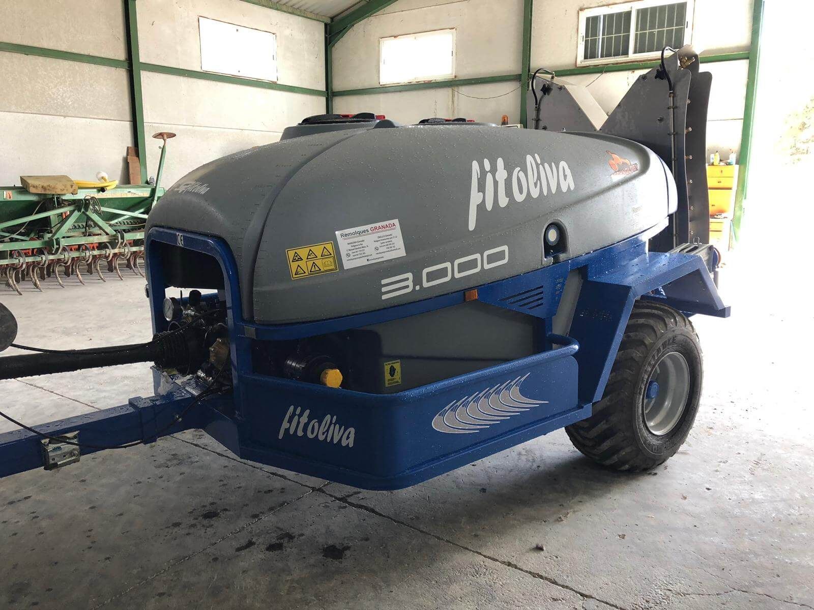 Un tractor azul y gris está estacionado en un almacén.